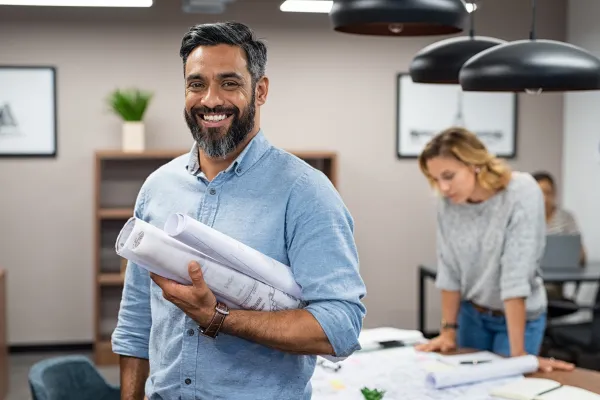 a man holding blueprints for a project