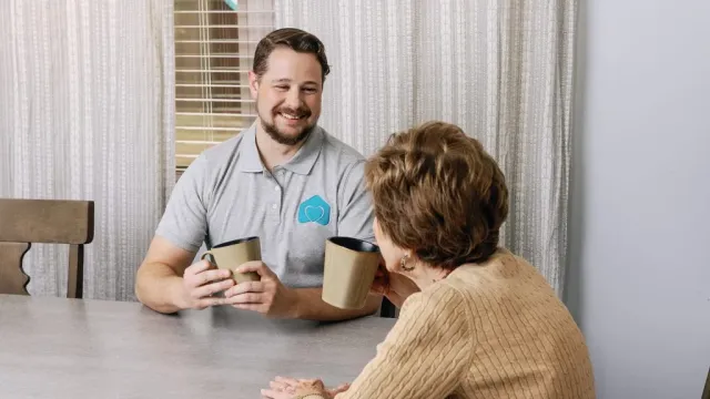 a man and a woman sitting at a table looking at a cell phone