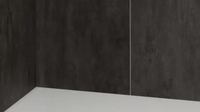 Minimalist white shower base with dark textured wall panels and circular floor drain in corner