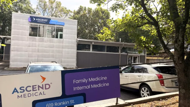 Ascend Medical family and internal medicine clinic with sign and parked cars outside under trees.