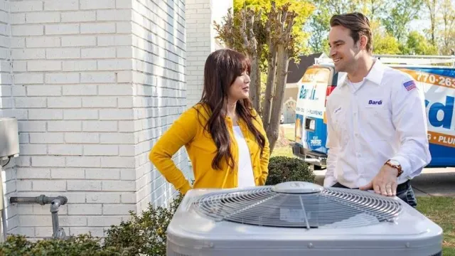 Customer discussing HVAC unit with technician outside home near service van on sunny day
