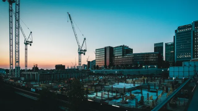 a construction site with cranes and buildings