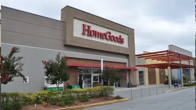 Exterior view of HomeGoods store with signage, landscaping, and adjacent retail buildings under cloudy sky