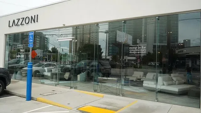Modern furniture store LAZZONI with glass front showcasing sofas and interior design signage in an urban setting