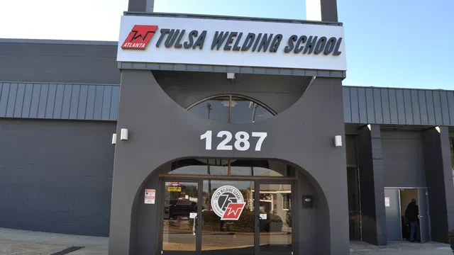 Entrance of Tulsa Welding School building with address 1287 and school logo on glass doors under clear sky.