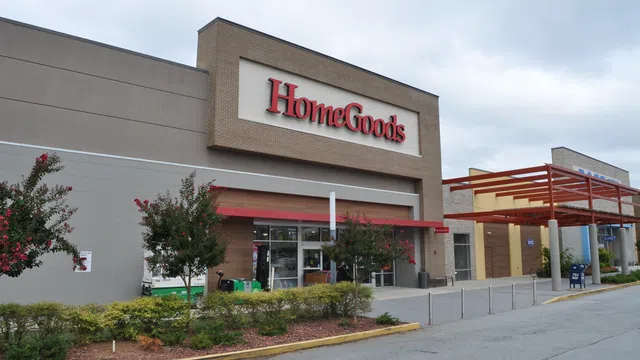 Exterior view of a HomeGoods store with clear signage and landscaped entrance under a cloudy sky.