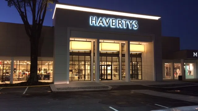 Havertys furniture store exterior at night with illuminated signage and empty parking spaces.