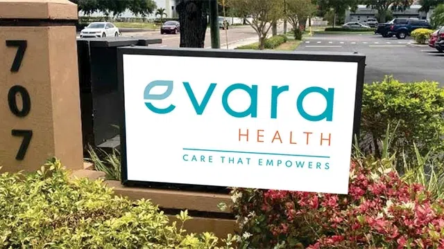 Evara Health sign with tagline Care That Empowers near building number 707 surrounded by plants.