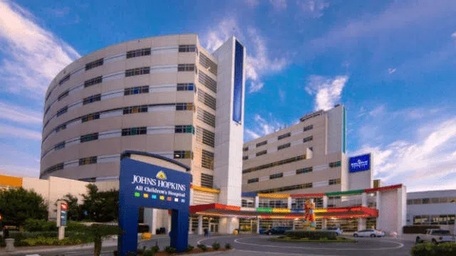 Johns Hopkins All Children's Hospital exterior with clear blue sky and modern hospital building.