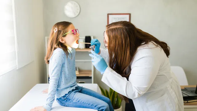 Female healthcare professional thoughtfully listening during a medical team meeting in a modern office.