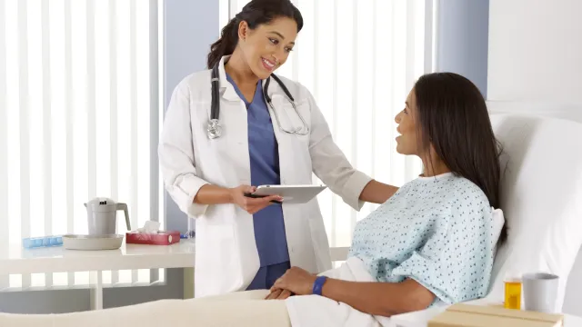 a doctor showing a patient something on the tablet