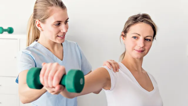 a woman holding a green object next to a woman in a white shirt