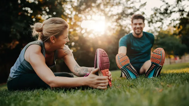 a woman and a man sitting on grass