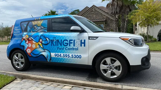 White and blue Kingfish Pest Control vehicle with cartoon fish mascot parked on suburban street