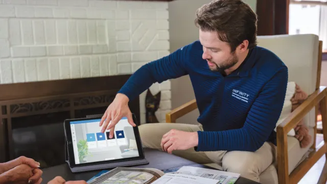 a man sitting at a table with a tablet and a stack of books
