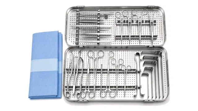 Sterile surgical instruments arranged in a metal tray with a folded blue surgical drape on the side.