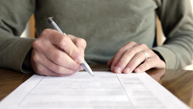 a person writing on a piece of paper