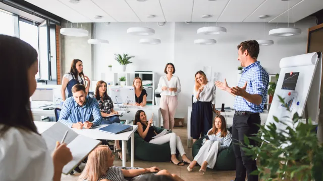 Group meeting in a modern office space with engaged participants discussing ideas and brainstorming.