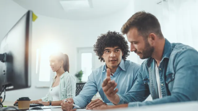 A group of diverse professionals collaborating in a modern office space, discussing ideas and projects.