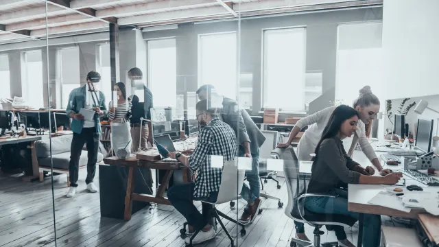 Modern office setting with team collaboration and creative work in progress.