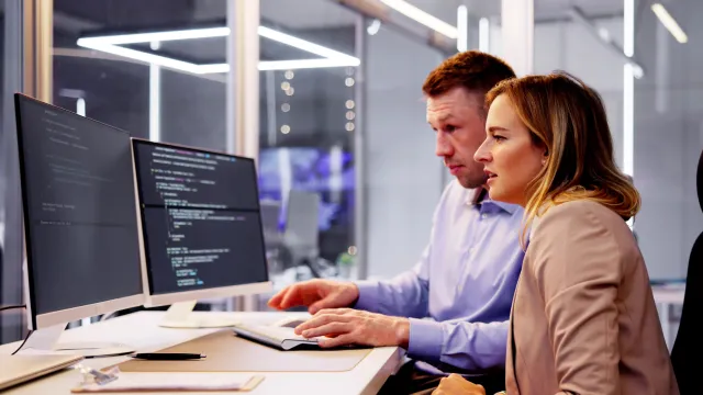 a man and a woman looking at a computer screen