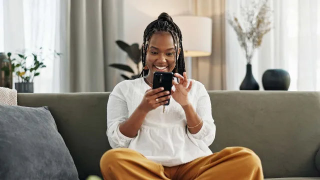 a person sitting on a couch and holding a phone