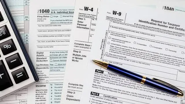 Calculator, tax forms 1040, W-4, W-9, and blue pen arranged for tax filing preparation.