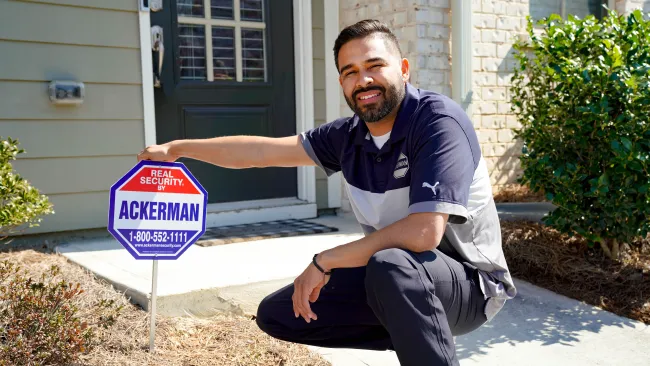 a man sitting on a curb next to a sign