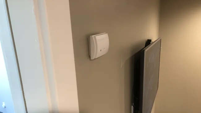 a white wall with a black rectangular object on it