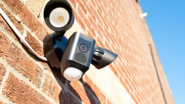 a couple of black and silver cameras on a brick building