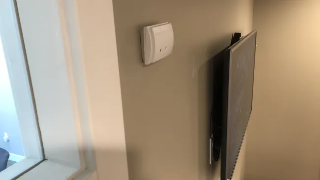 a white wall with a black rectangular object on it