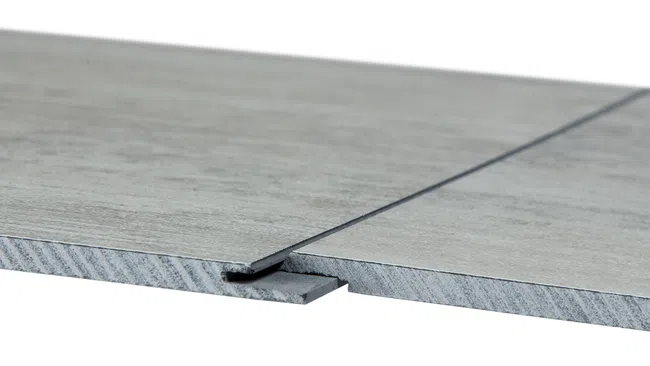 Close-up of two interlocking grey laminate floor panels showing tongue and groove design on white background