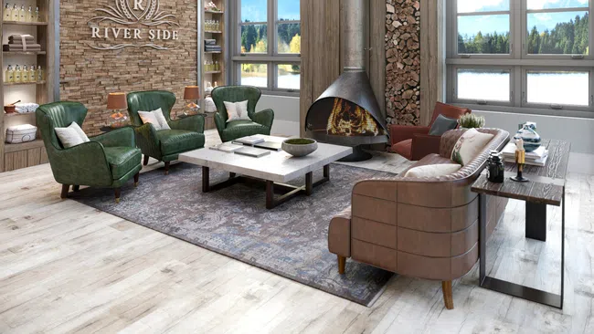 Cozy modern living room with leather chairs, stone fireplace, large windows, and scenic mountain views at Riverside.