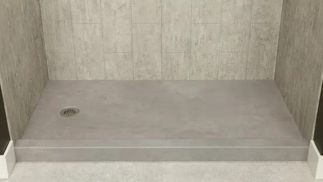 Minimalist beige tiled shower area with a raised platform and central drain cover in modern bathroom.