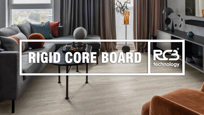 Modern living room with gray couch, orange chair, wood-look rigid core flooring, and large window with curtains