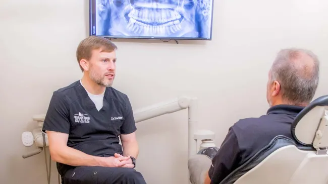 a person sitting in a chair next to another man