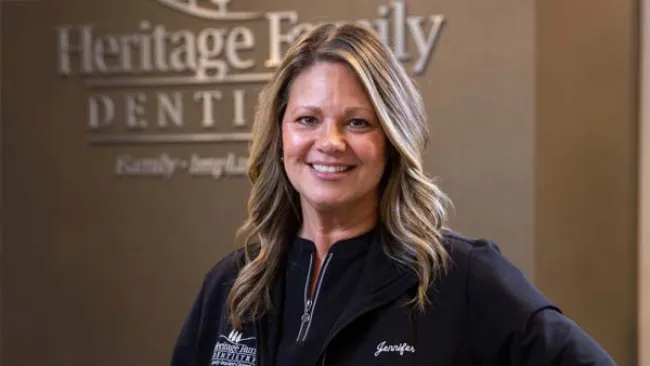 a woman smiling in front of a sign