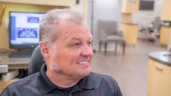 a man smiling in front of a computer