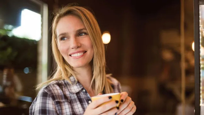 a woman holding a cup