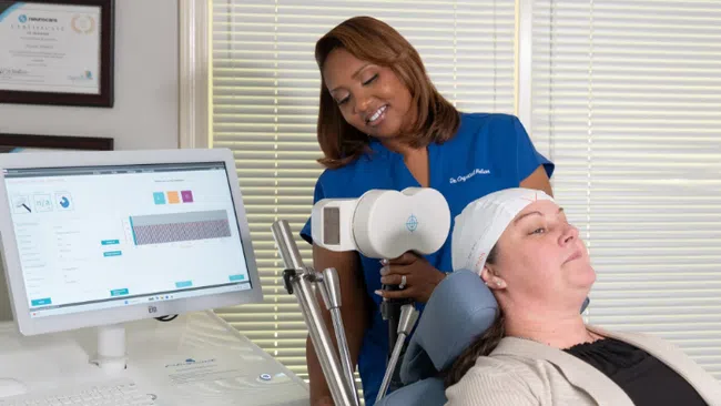 Medical professional using advanced brain monitoring equipment on a relaxed patient in clinical setting