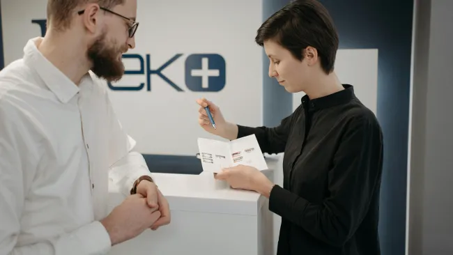 a man showing a woman something on a paper