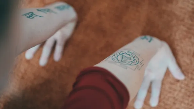 a person's hand holding a piece of paper with writing on it