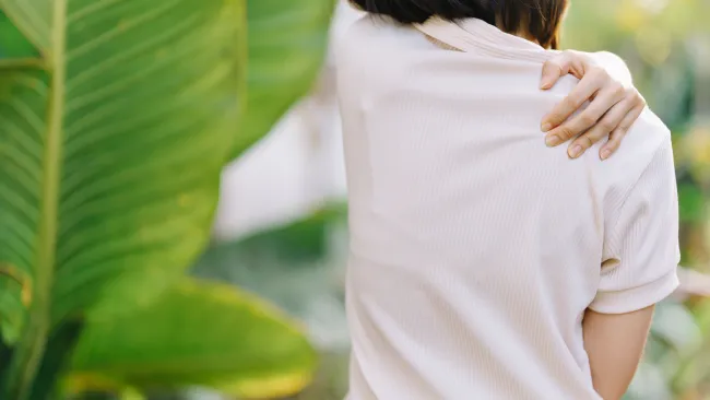 a person touching their shoulder