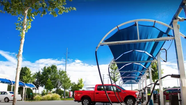a red truck parked next to a large metal structure