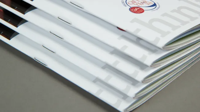 Stack of professional booklets with a clean design, featuring logos and modern graphics.