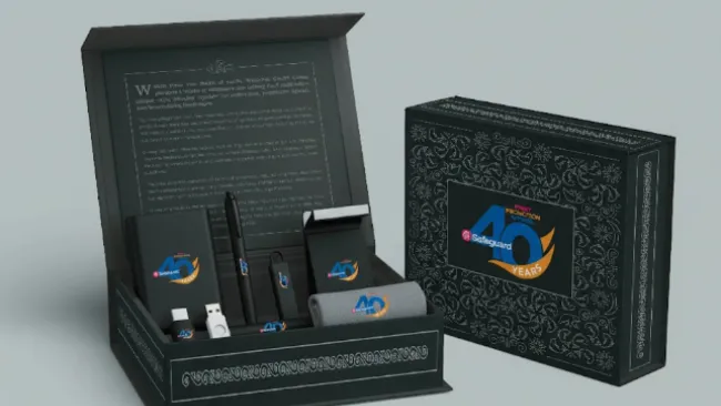 Black gift box set with branded 40th anniversary items including USB, pen, and towel with ornate patterns