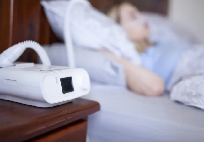 a cpap machine sitting on top of a nighstand.