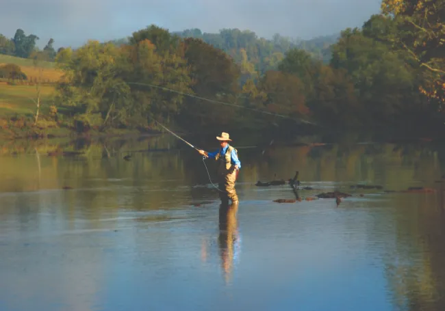 a person standing next to a body of water.