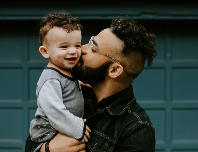 a man kissing a child