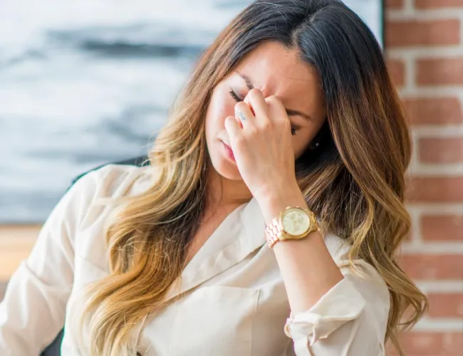 a woman covering her face with her hands